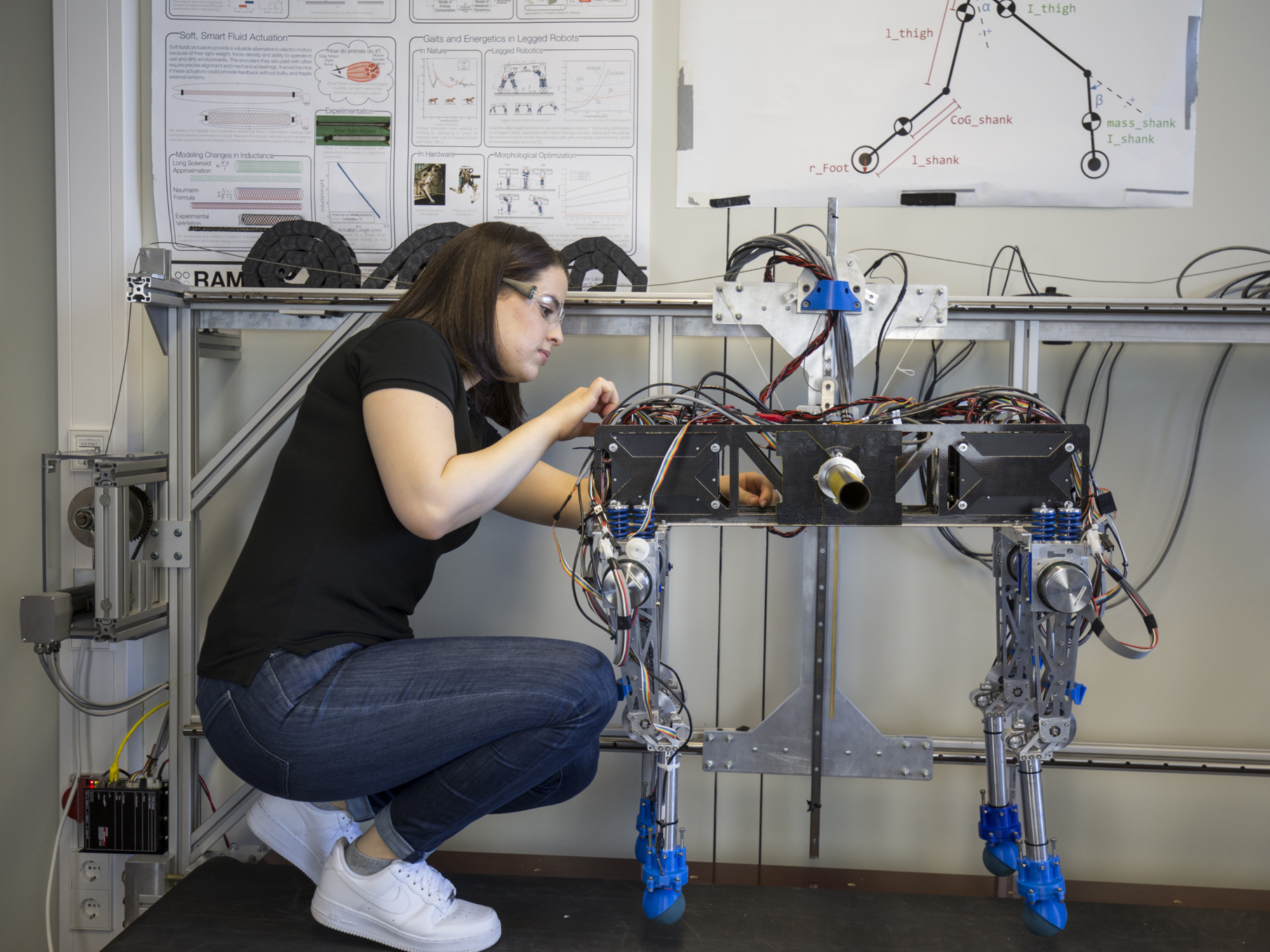 Eine Studentin arbeitet an einem vierbeinigen Roboter.